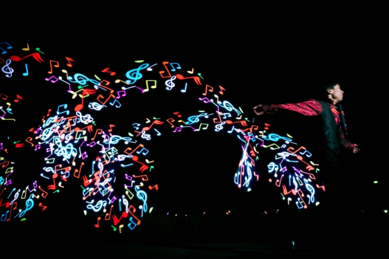 暗転した会場でLEDのグラフィックポイが空中に絵を描くパフォーマンス
