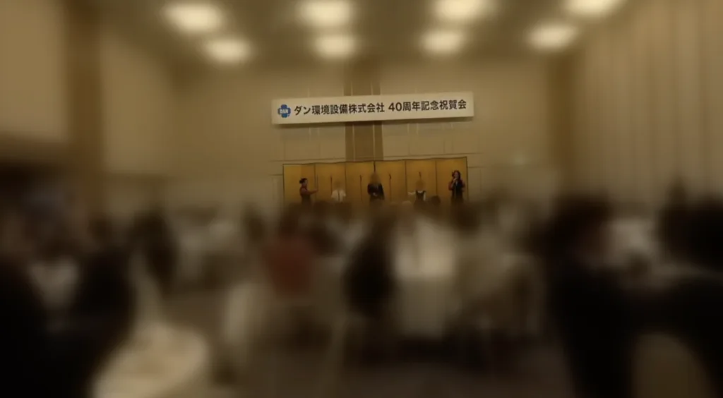 ダン環境設備株式会社40周年記念祝賀会で社長とお子さん2人が1本のLEDポイを一緒に回す様子