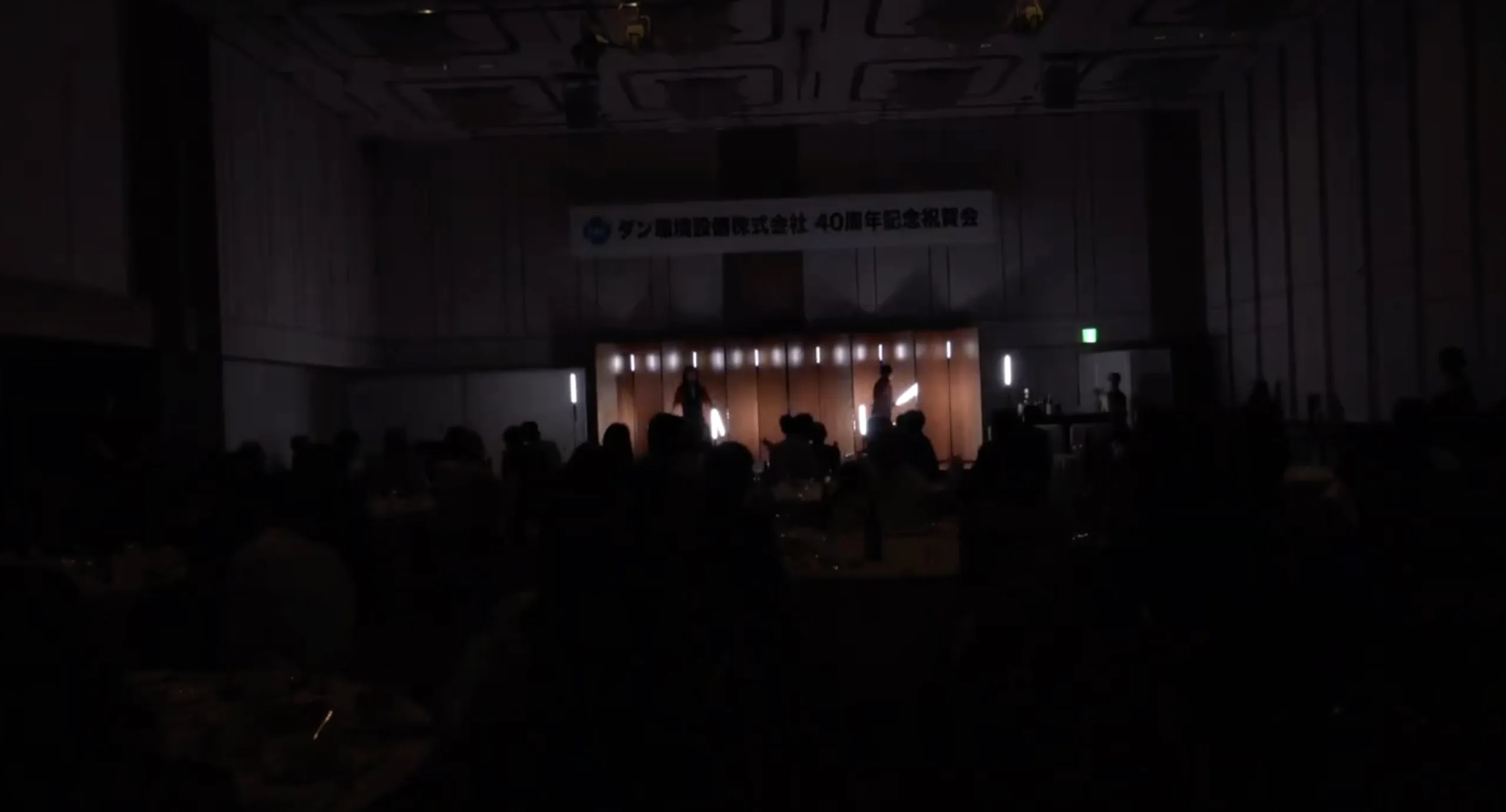 暗転した宴会場でLEDポイを回すLEDアートパフォーマー池田優輝 音辻の2人によるPoi Graphics